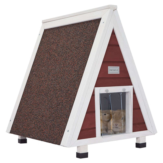 A-frame wooden cat house in red and white finish with asphalt roof and clear strip door, shown with two rabbits peeking out.