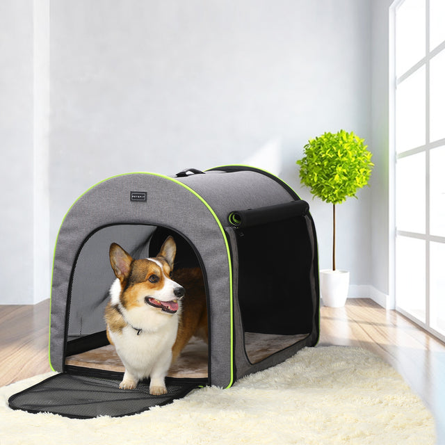 Corgi stands at the open doorway of a soft dog crate in a bright living room, blending neatly with modern home decor.