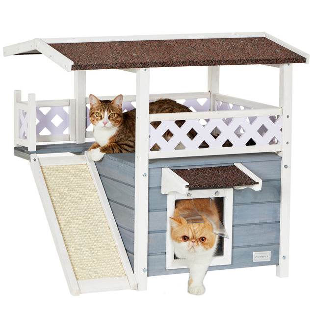 PETSFIT 2-story gray and white outdoor wooden cat house with sisal ramp, upper balcony with lattice fence, and PVC curtain door, two tabby cats inside and on top