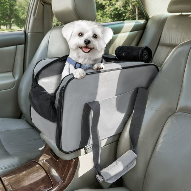 White Maltese dog sitting inside PETSFIT light gray console dog car seat installed in center console of car, showing main product lifestyle view