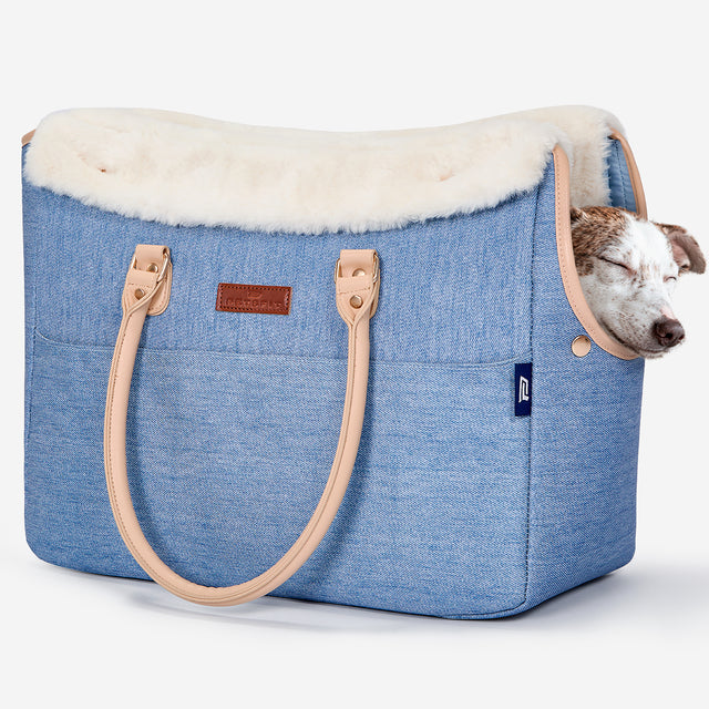 Pet owner carrying PETSFIT denim pet tote outdoors with small dog inside
