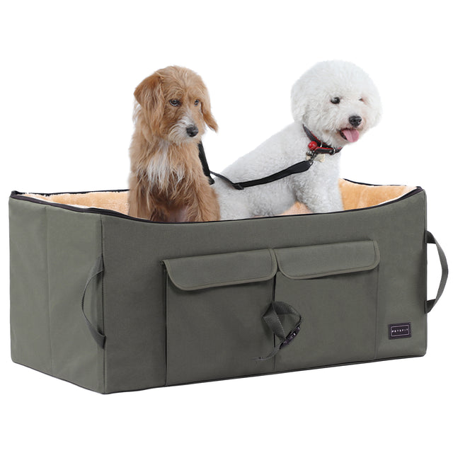 Two small dogs sit comfortably inside a plush-lined dog car seat, secured with a tether for safer shared travel.