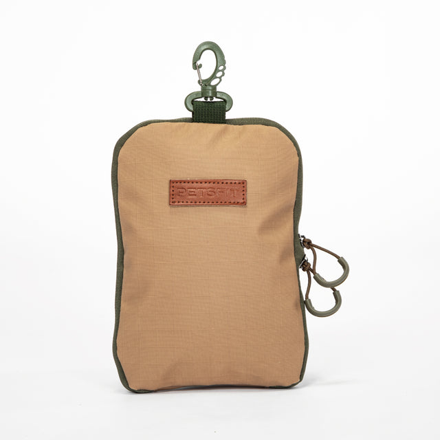 Olive gear bag for dog backpack trips, carried by hand with long handles, side pockets, and tan work boots.