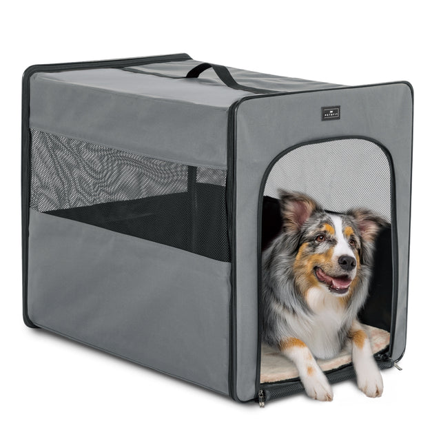 A soft gray Petsfit indoor dog bed placed next to a sofa in a modern living room