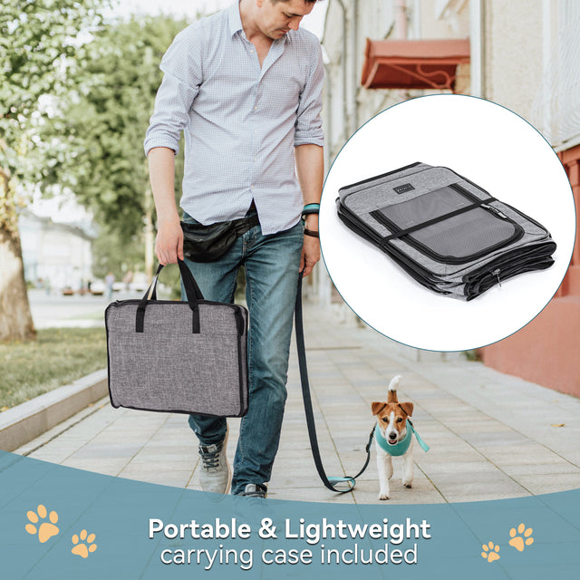 Man carries folded gray travel playpen in a matching tote while walking a small dog, highlighting lightweight portable setup.