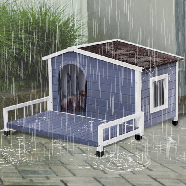 Blue outdoor dog house stands on a wet patio in heavy rain, with roof runoff and covered doorway sheltering a small dog inside.