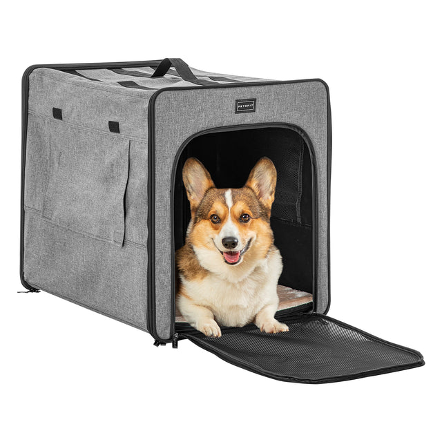 Corgi sits at the entrance of a gray collapsible dog crate with front mesh flap lowered and interior cushion visible inside.