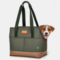 Olive green pet carrier tote with tan leather base and webbing straps, small puppy peeking out of the zippered top