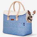 Pet owner carrying PETSFIT denim pet tote outdoors with small dog inside