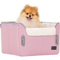 Fluffy Pomeranian sitting in a pink dog car seat with plush fleece lining and raised sides, giving a cozy secure ride feel.