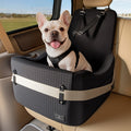 French Bulldog sitting in PETSFIT dog car seat on rear vehicle seat, headrest straps and black exterior visible