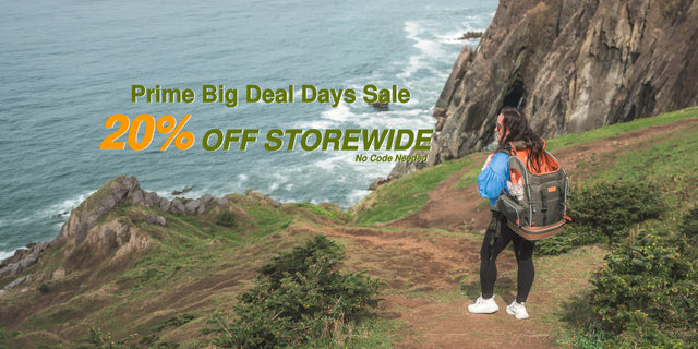 Prime Big Deal Days 20% off banner: woman on a coastal cliff trail above the ocean carrying a cat in a pet backpack (desktop version)
