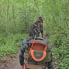 Hiker with tabby cat sitting on top of PETSFIT WILDPATH green cat carrier backpack on forest trail boardwalk